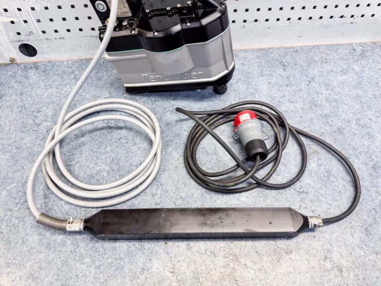 A drill motor with cable and EMC-filter on a work bench